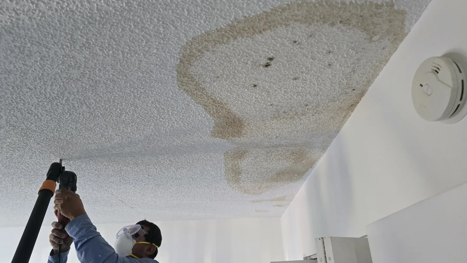Technician checking a water stain on a popcorn ceiling