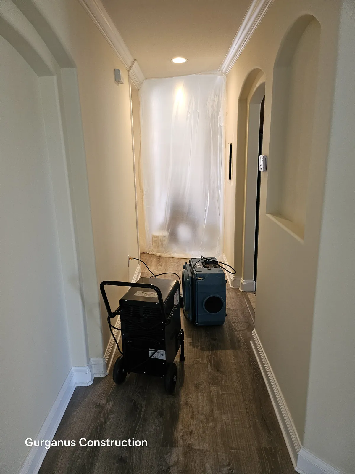 Dehumidifier and air scrubber in a hallway outside a contained room